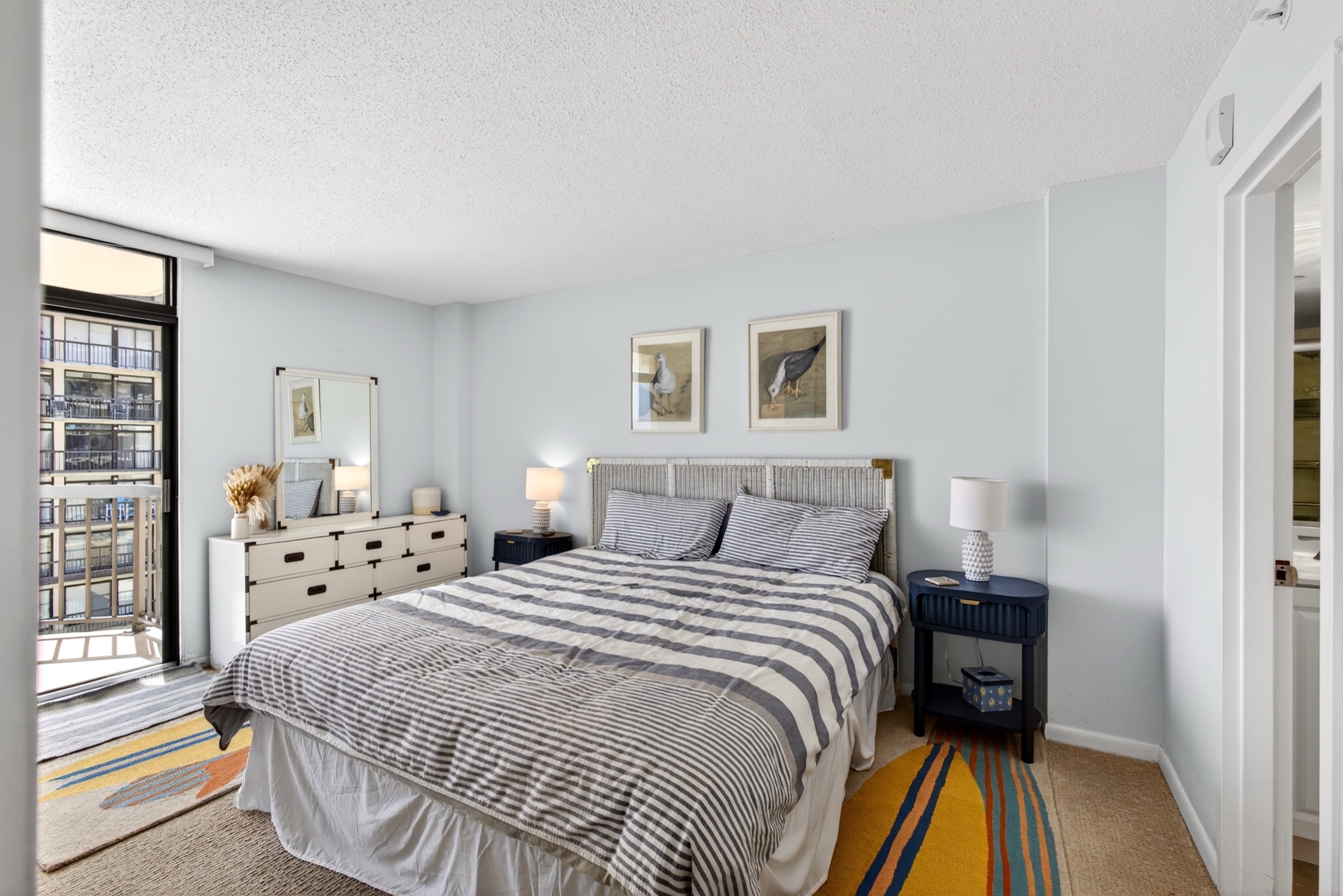 Syracuse Airbnb photography — king bedroom with coastal styling and balcony view