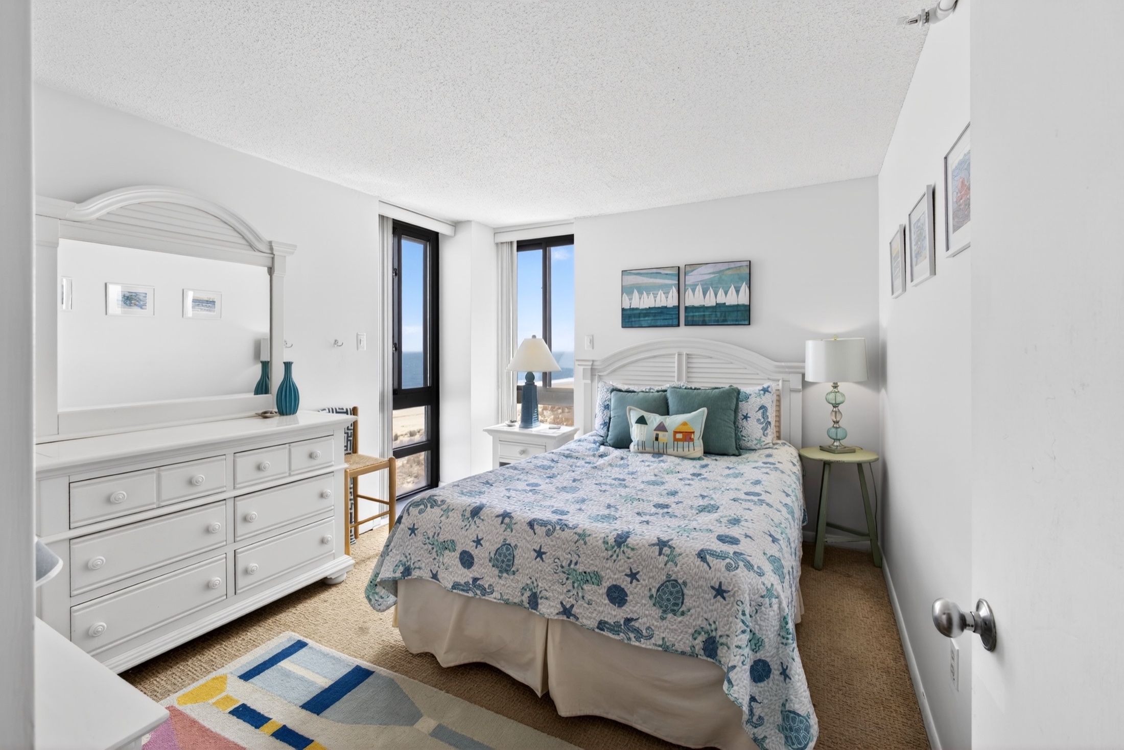 Syracuse Airbnb photography — primary bedroom with sea-themed bedding and ocean window
